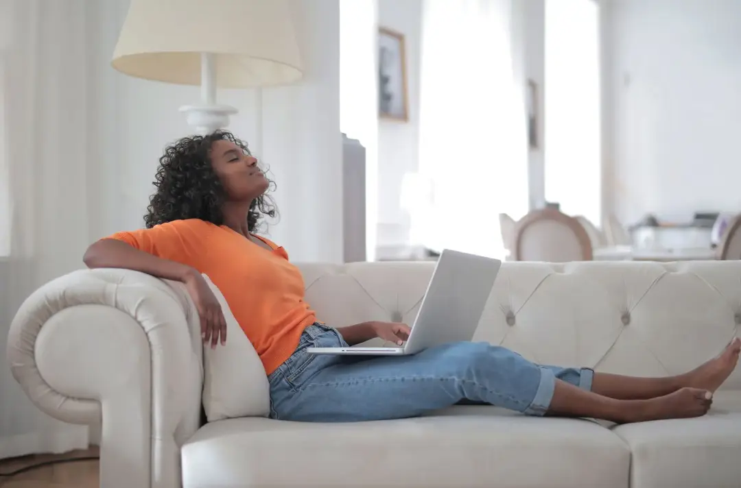 Woman lounging on sofa in air conditioned room